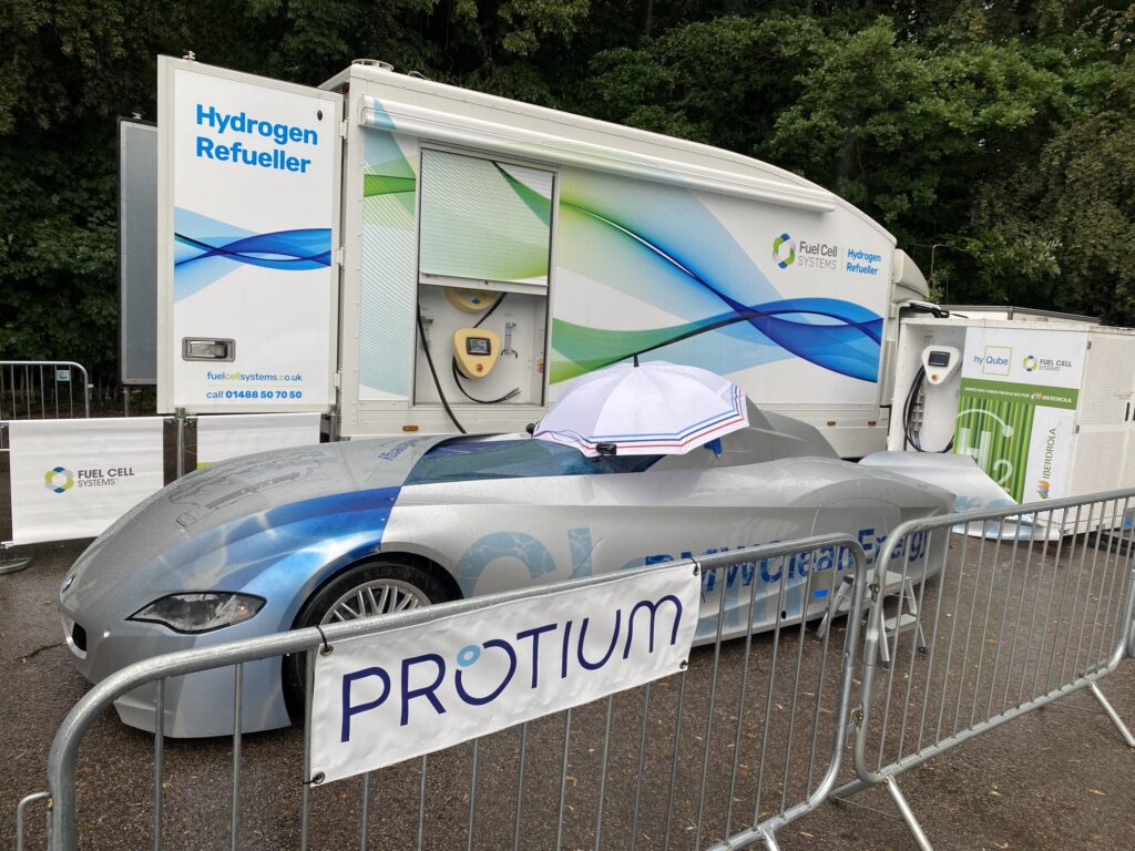 Hydrogen-powered Protium race car displayed next to Fuel Cell Systems hydrogen refueling station at Goodwood Festival of S...