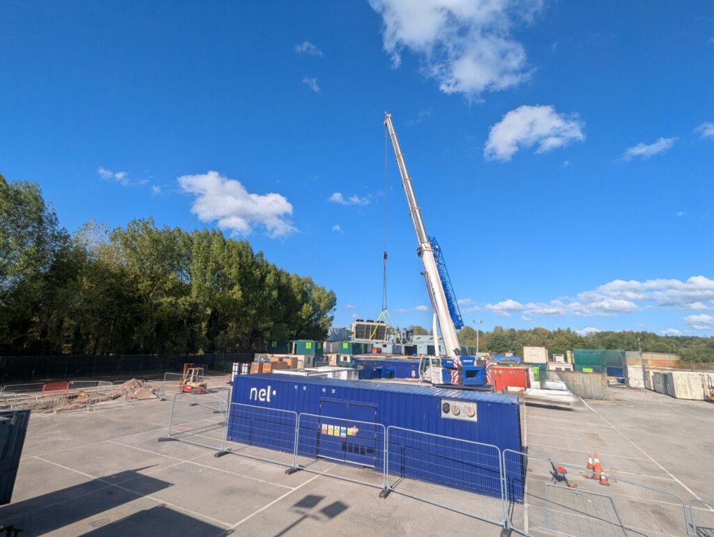 Construction site with crane and blue equipment for Protium's green hydrogen facility in South Wales