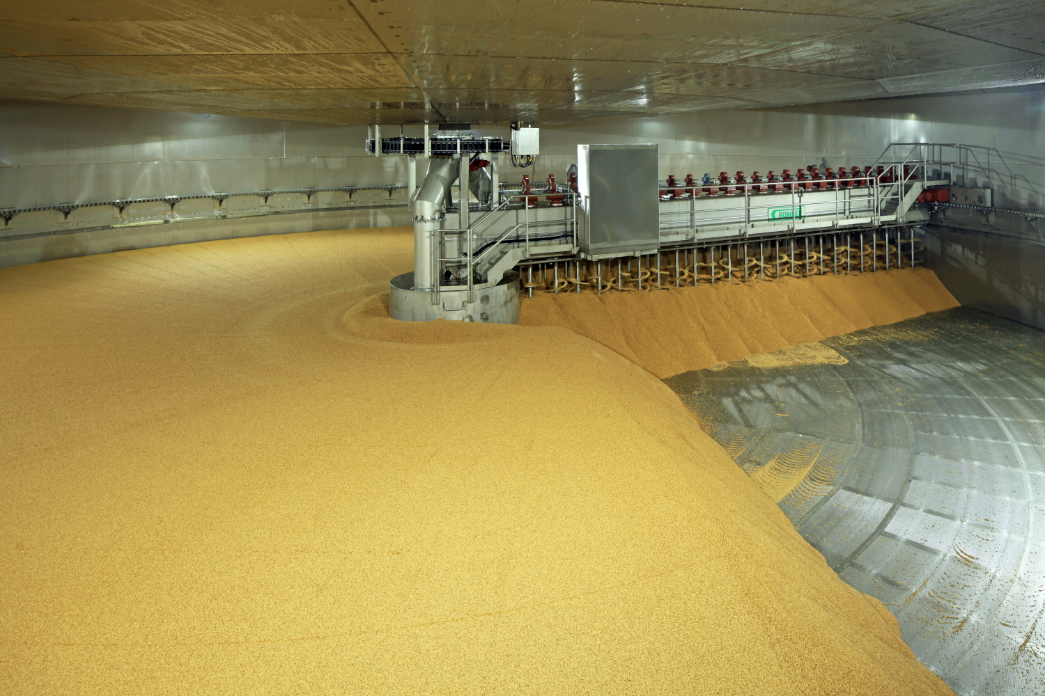 Interior of a large industrial malting facility, showing storage silos filled with malted barley.