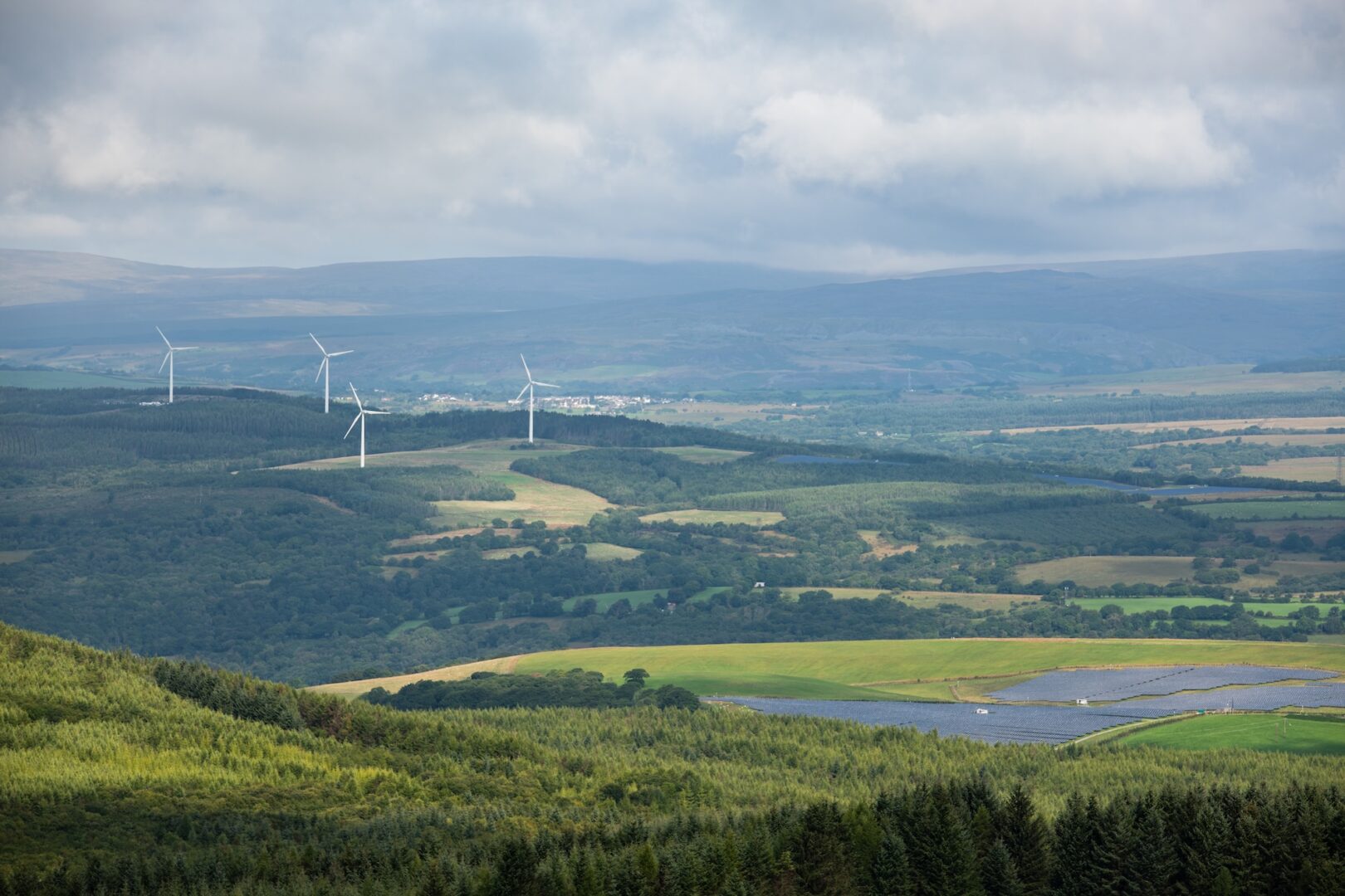Solar panel and wind turbine farms in Rhondda Cynon Taf, Mid Glamorgan, Wales, UK landscape.