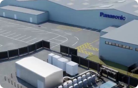 Panasonic manufacturing facility with parking lot, loading dock, and industrial buildings in aerial view.