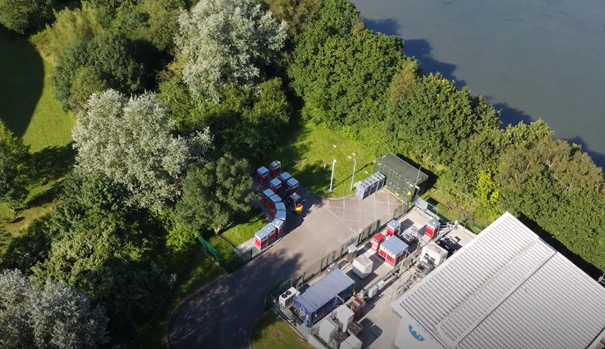 Aerial view of Protium Pioneer I site showing industrial facility with red containers, buildings, and equipment surrounded...